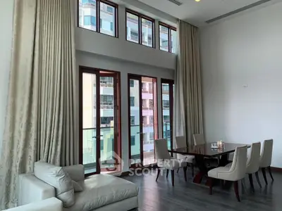 Spacious living room with high ceilings and elegant dining area in modern apartment