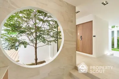 Modern minimalist entrance with circular window and tree view