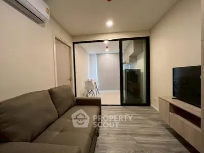 Modern living room with cozy sofa and open view to dining area and kitchen.