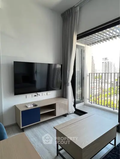 Modern living room with large TV and balcony view in urban apartment