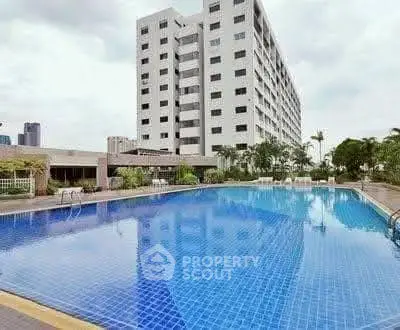 Luxurious residential building with a stunning outdoor pool and lush greenery.