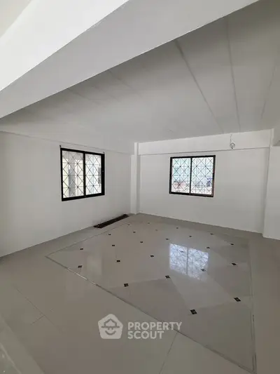 Spacious unfurnished room with tiled flooring and large windows, perfect for customization.