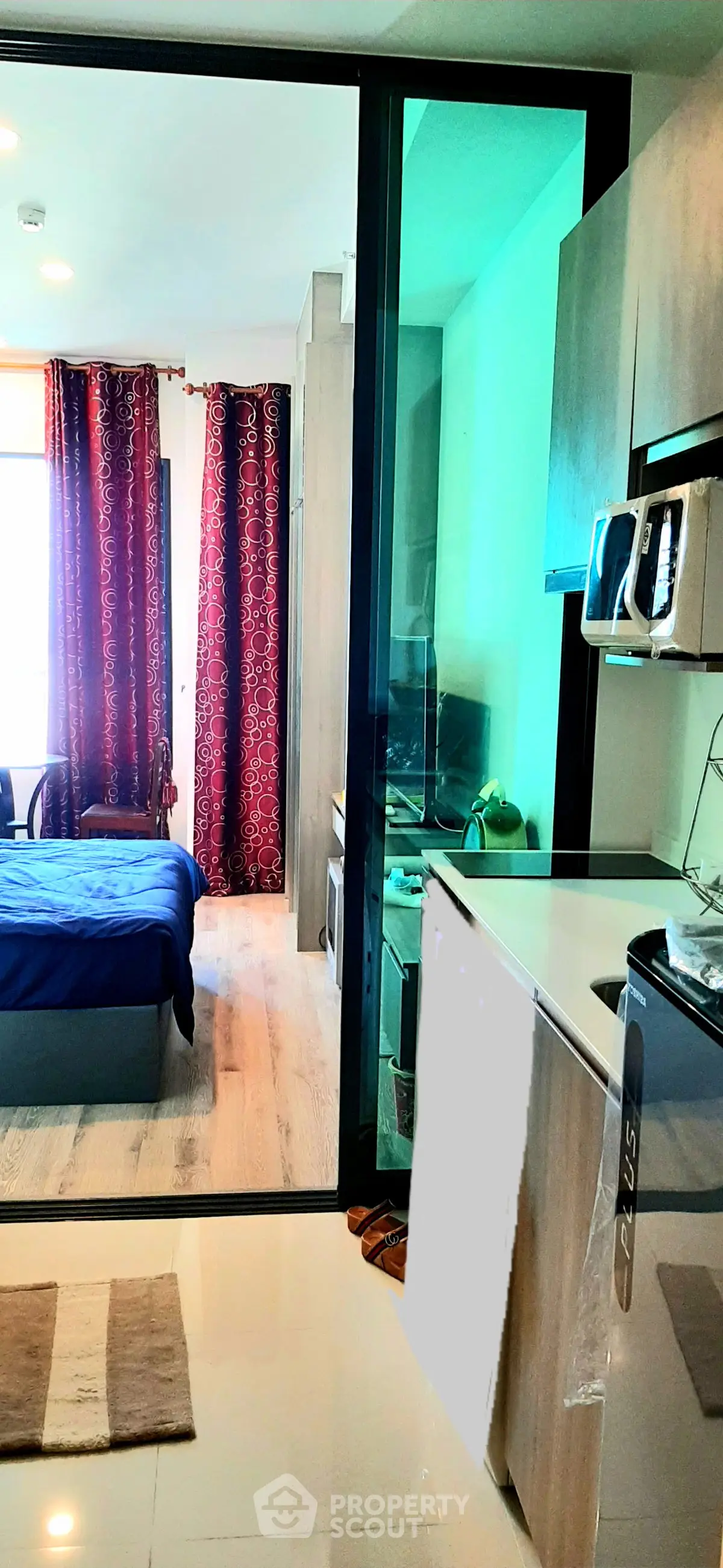 Modern studio apartment with open kitchen and cozy bedroom, featuring stylish decor and natural light.