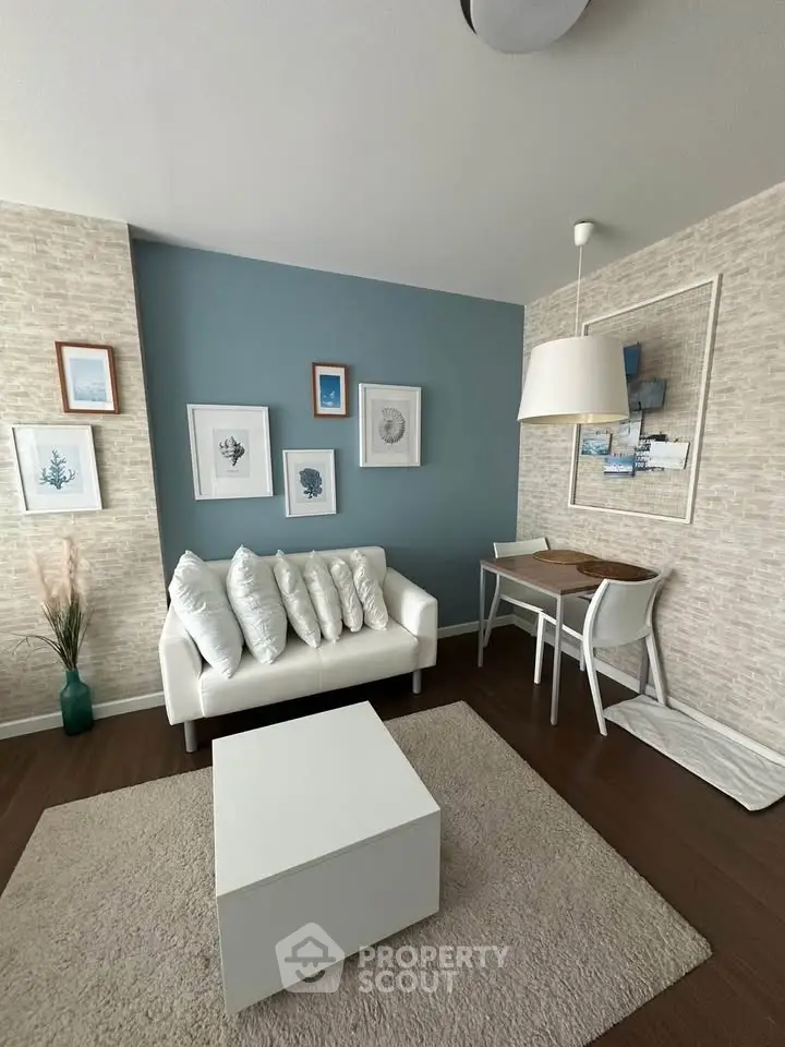 Chic living room with modern decor, white sofa, and stylish artwork on blue accent wall.