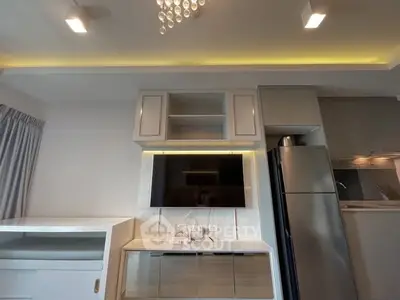 Modern living room with built-in TV unit and sleek kitchen appliances