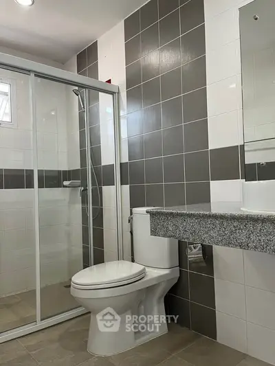 Modern bathroom with sleek shower enclosure and contemporary fixtures.