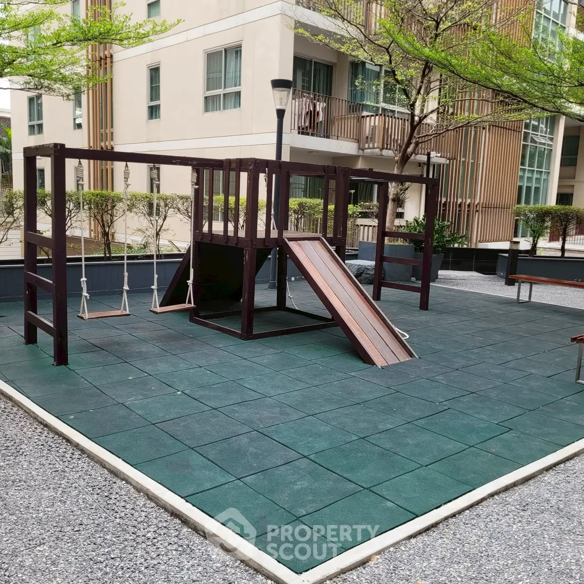 Modern apartment building with playground in lush green setting