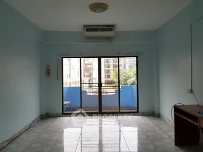 Spacious living room with large windows and balcony view