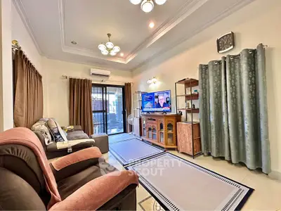 Spacious living room with elegant decor and large TV, perfect for relaxation and entertainment.
