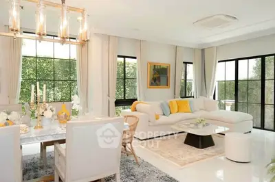 Luxurious open-plan living room with elegant dining area and large windows offering natural light.