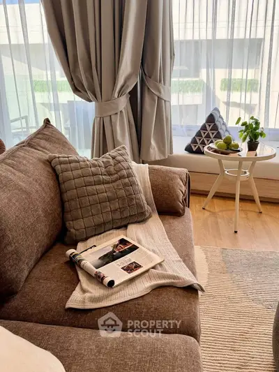 Cozy living room with plush sofa and elegant curtains, perfect for relaxation.