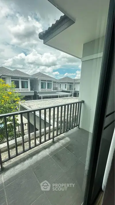 Spacious balcony with scenic view of modern residential neighborhood under a bright sky.