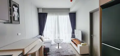 Modern living room with sleek furniture and large window, perfect for urban living.