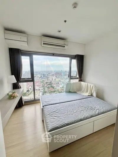 Modern bedroom with stunning city view and large windows in high-rise apartment.