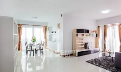 Spacious modern living room with dining area, elegant decor, and abundant natural light.