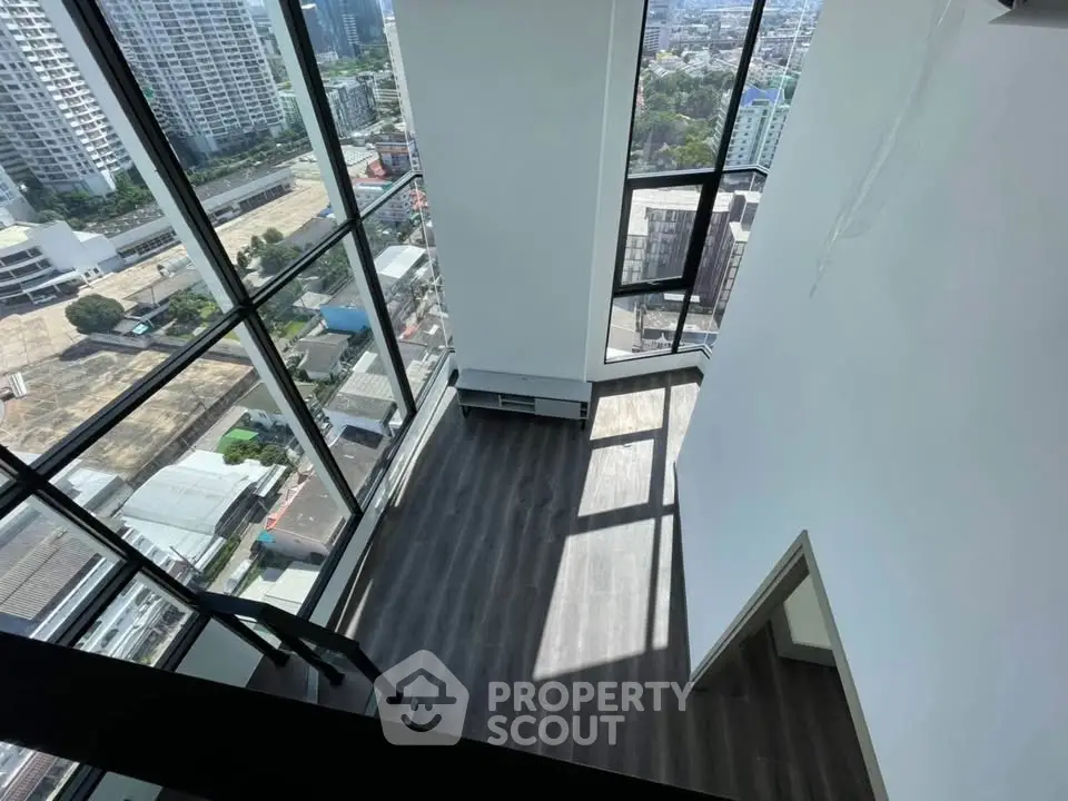 Stunning high-rise apartment with floor-to-ceiling windows offering panoramic city views.