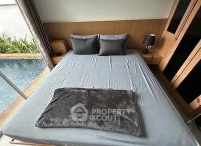 Luxurious bedroom with pool view and modern furnishings in a stylish home.