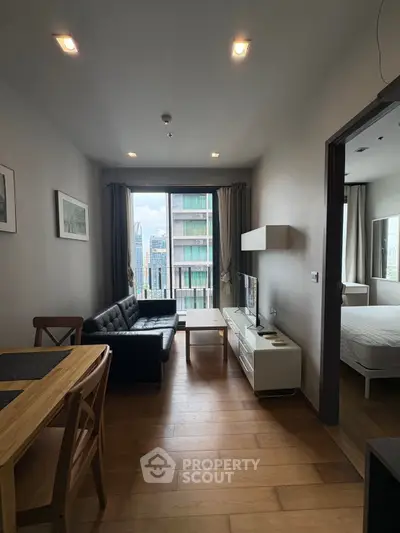 Modern living room with wooden flooring and city view, featuring a black sofa and dining area.