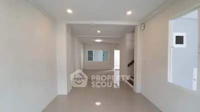 Spacious open-plan living area with modern lighting and glossy tiled floors.