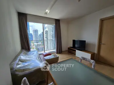 Modern living room with city view, featuring a wrapped sofa and flat-screen TV, ideal for urban living.