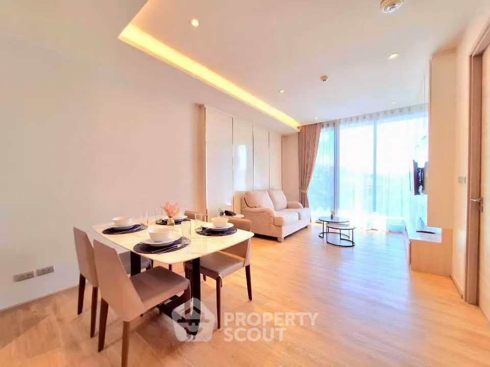 Spacious modern living room with dining area and large windows offering natural light.
