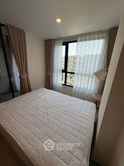 Cozy bedroom with large window and modern decor in urban apartment