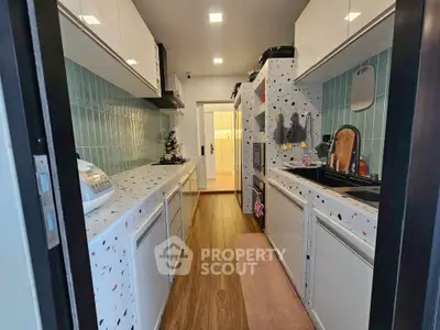 Modern kitchen with terrazzo countertops and sleek cabinetry in a stylish apartment.