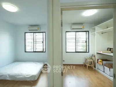 Spacious bedroom with wooden flooring and ample natural light