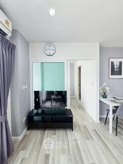 Modern living room with sleek decor and wall-mounted clock