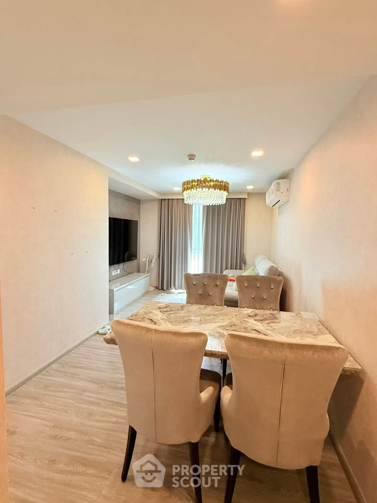 Elegant living room with modern decor and stylish chandelier in a cozy apartment setting.