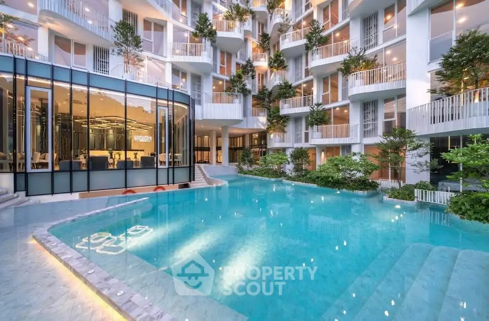Luxurious modern apartment complex with stunning pool and lush greenery, perfect for urban living.