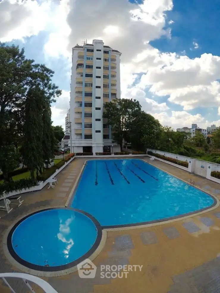 Luxurious apartment building with a stunning outdoor pool and lush greenery, perfect for relaxation and leisure.