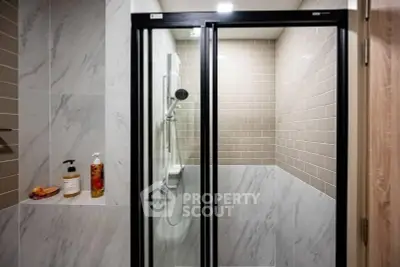 Modern bathroom with sleek shower enclosure and stylish tile design.