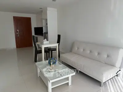 Modern living room with white sofa and sleek dining area in open layout.