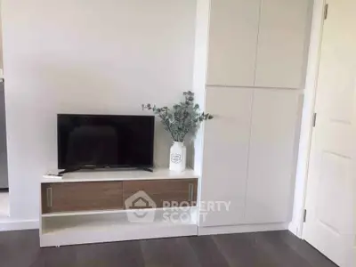 Modern living room corner with TV and sleek storage cabinets.