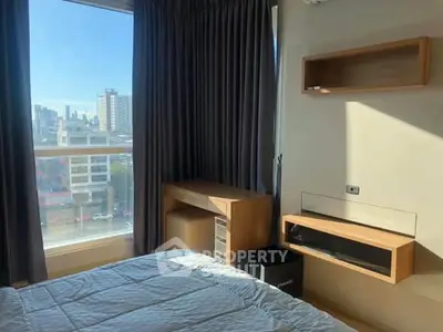 Modern bedroom with city view, featuring sleek furniture and large window.