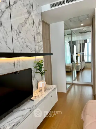 Stylish modern living room with marble accents and mirrored wardrobe in a cozy apartment.