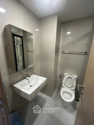 Modern bathroom with sleek fixtures and neutral tiles, perfect for a contemporary home.