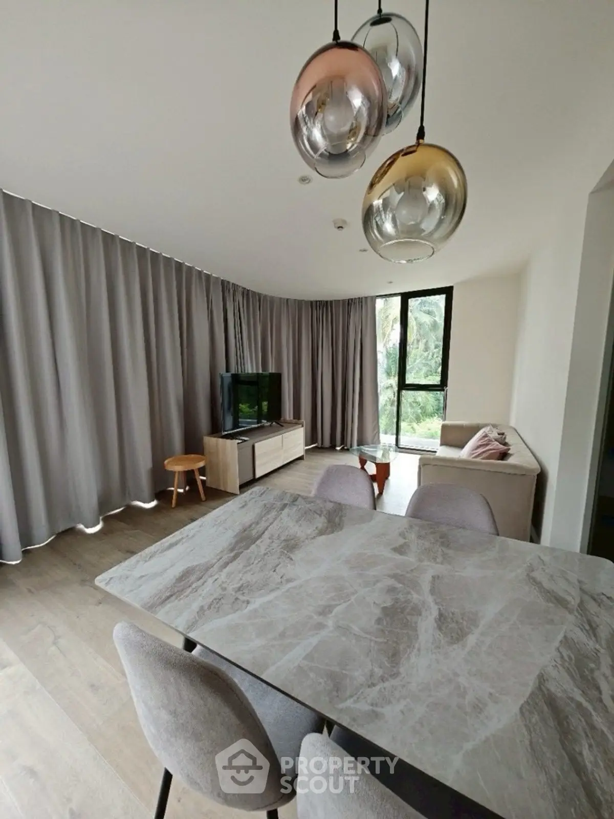 Modern living room with elegant dining area and stylish lighting fixtures.