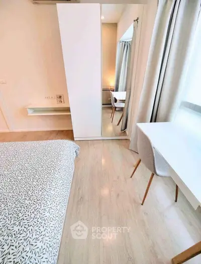 Modern bedroom with minimalist decor, featuring a cozy bed, sleek desk, and ample natural light.