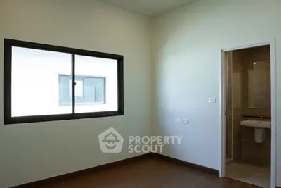 Minimalist bedroom with window and adjacent bathroom in modern apartment