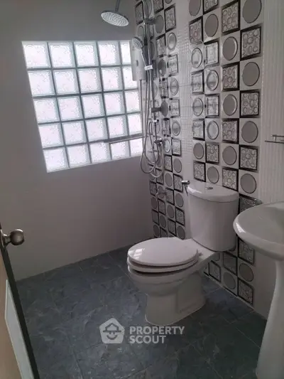 Modern bathroom with stylish tile design and glass block window