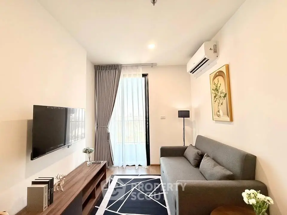 Modern living room with sleek furniture and natural light, featuring a stylish gray sofa and wall-mounted TV.
