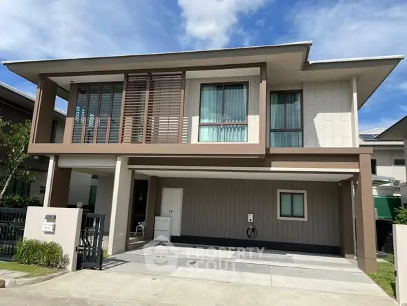 Modern two-story house with sleek design and spacious driveway in a suburban neighborhood.