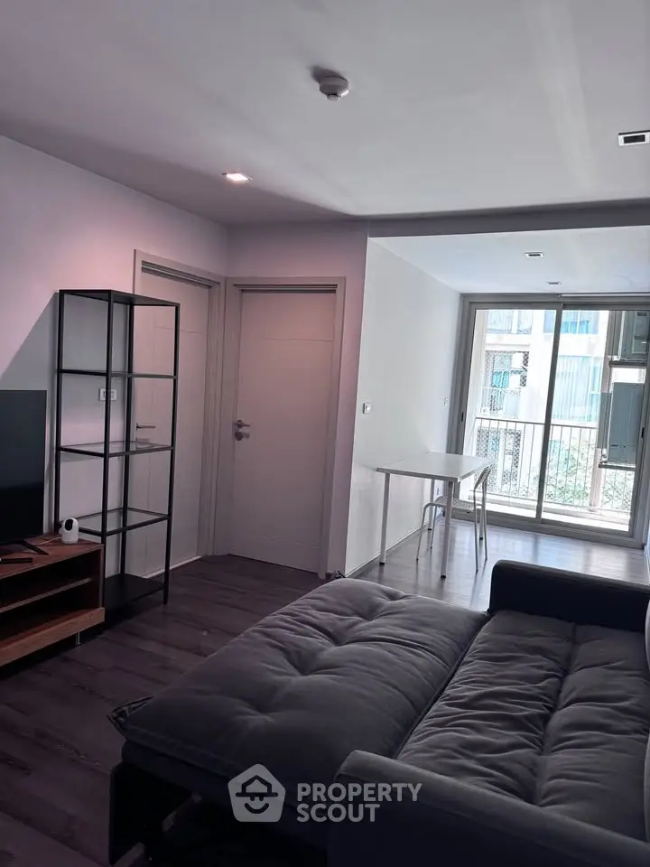 Modern living room with sleek furniture and large windows offering natural light.