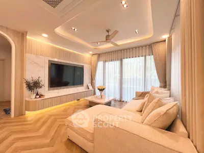Luxurious living room with elegant decor and large TV, featuring a cozy sectional sofa and floor-to-ceiling windows.