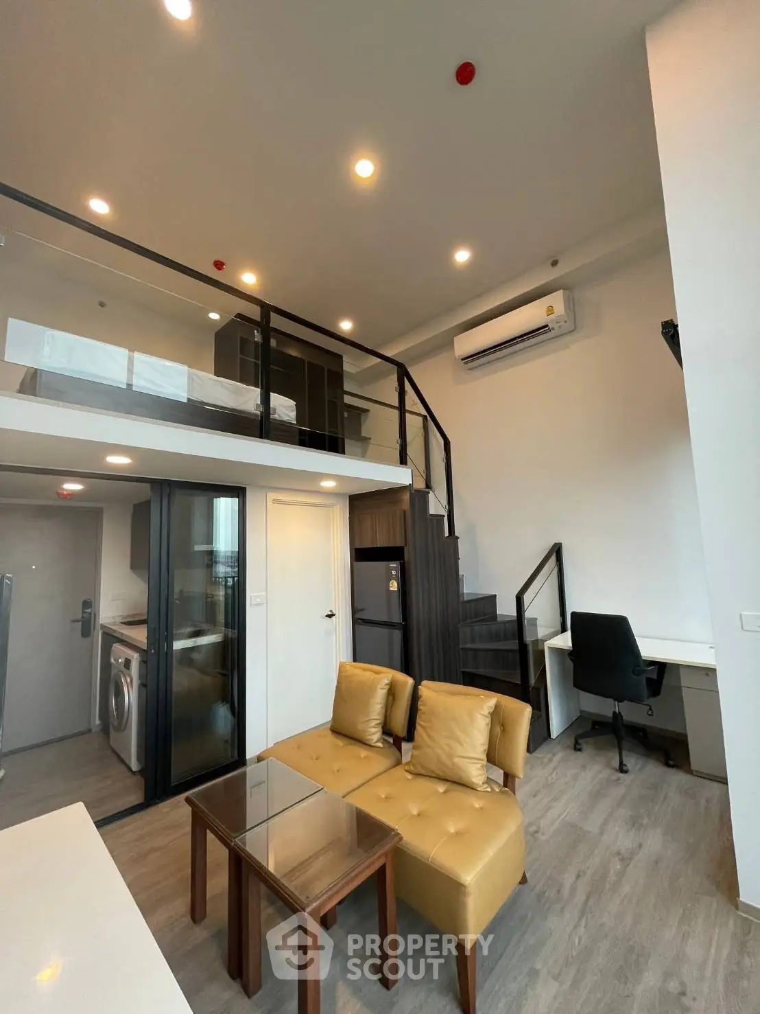 Modern loft apartment with mezzanine, stylish furniture, and open layout for urban living.