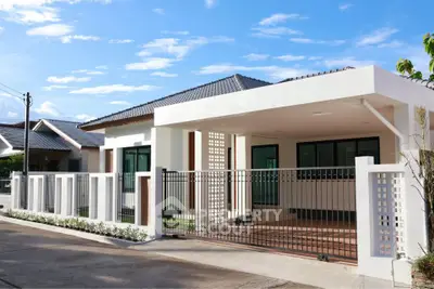 Modern single-story house with sleek design and spacious driveway in a serene neighborhood.