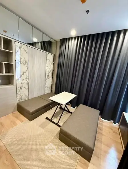 Modern living room with stylish furniture and elegant decor, featuring a marble accent wall and floor-to-ceiling curtains.