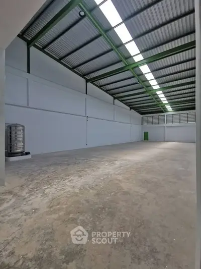 Spacious industrial warehouse with high ceilings and ample natural light.